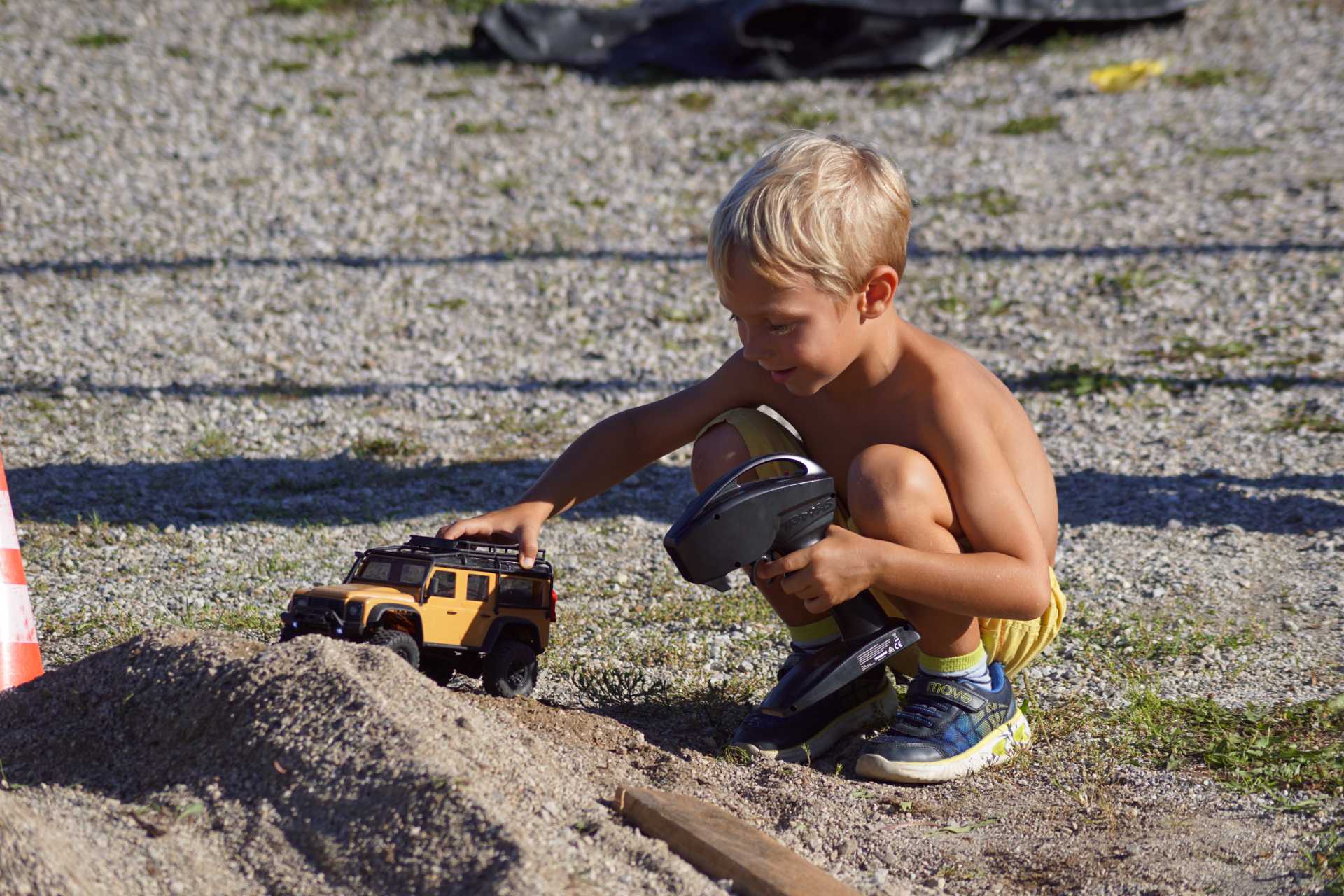 Kind spielt im Übungsparcour mit RC-Car